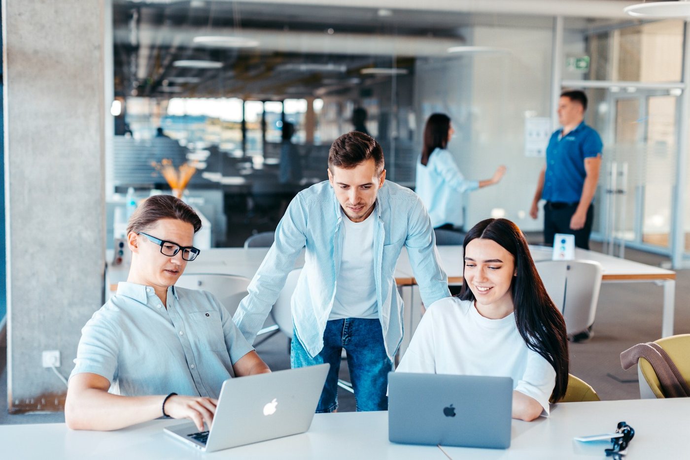 Colleagues working together at laptops in a modern office